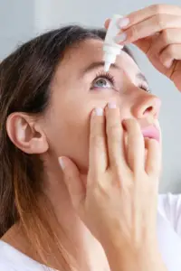 Mujer aplicándose gotas para los ojos